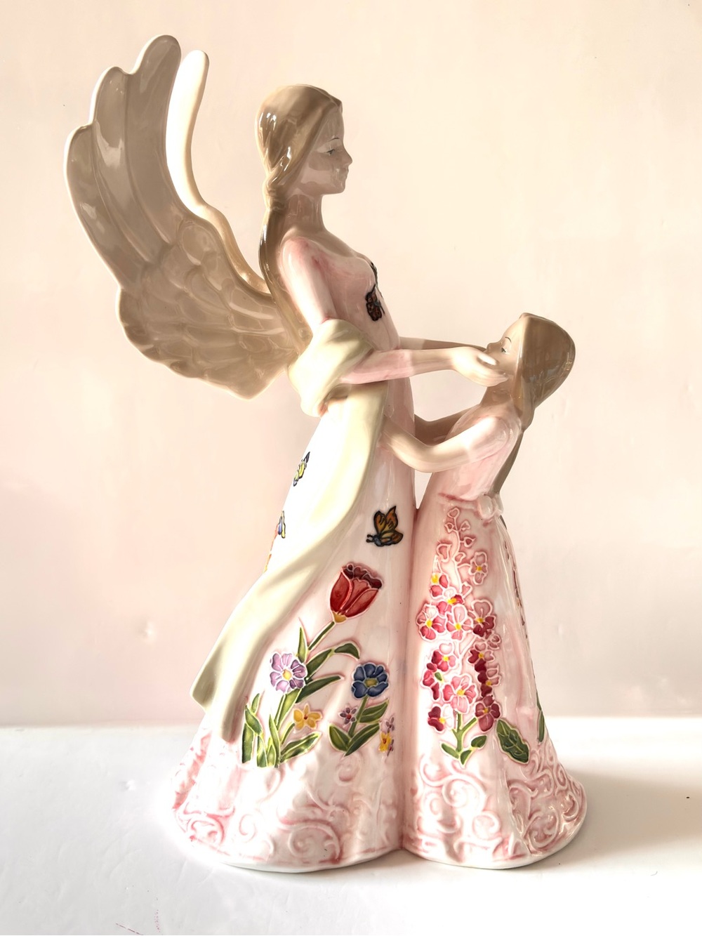 Fine porcelain figurine represents an angel with a little girl